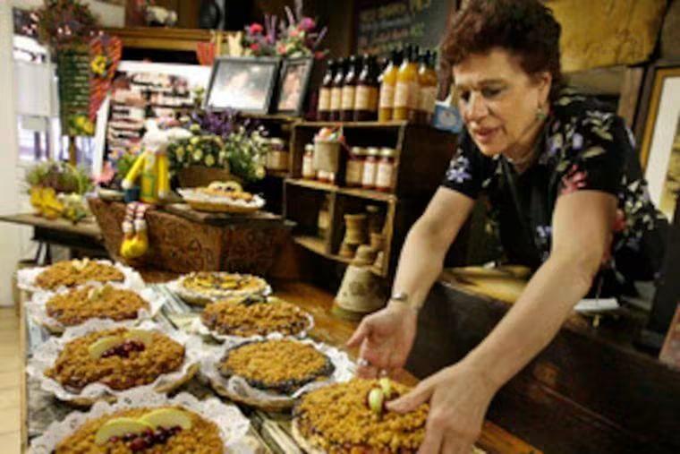 Evelyn Penza setting crumb-topped pies on the cafe counter